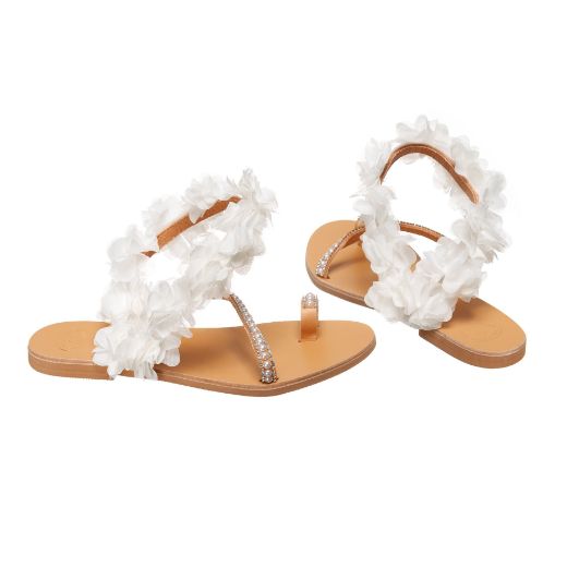 Handmade flat bridal sandals with white flowers around the ankle and rhinestone straps