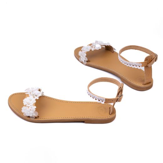 Χειροποίητα φλατ νυφικά σανδάλια με λευκά λουλούδια μπροστά