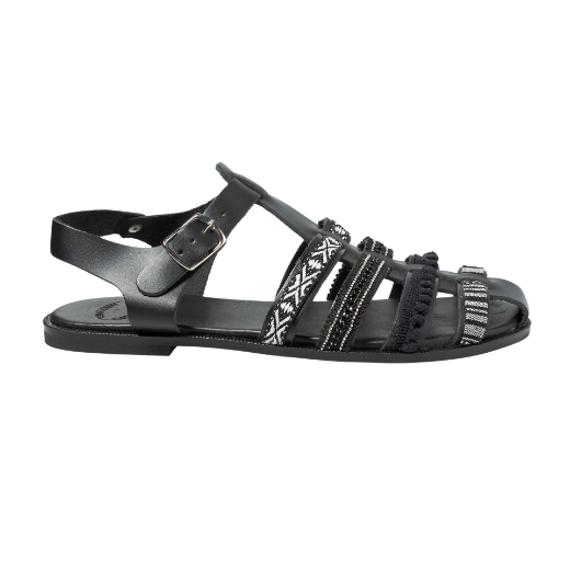 A black sandal featuring multiple straps with various textures and patterns, including a buckle strap around the ankle and decorative details on the upper straps.