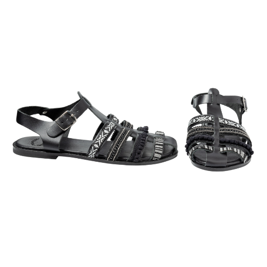 A black sandal featuring multiple straps with various textures and patterns, including a buckle strap around the ankle and decorative details on the upper straps.
