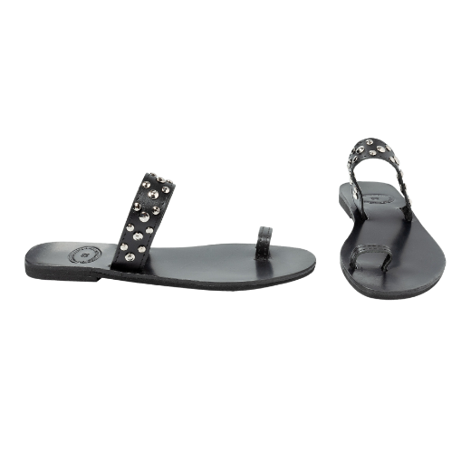 A black slip-on sandal with a single wide strap across the foot and a narrow toe strap, both decorated with metal studs.