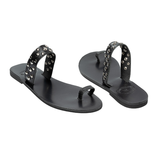 A black slip-on sandal with a single wide strap across the foot and a narrow toe strap, both decorated with metal studs.