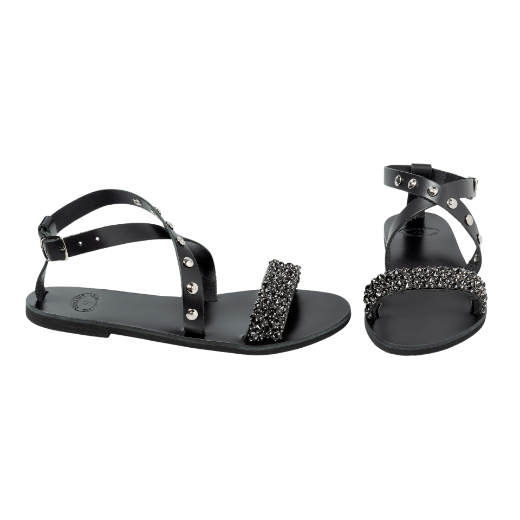 A black sandal with a buckle ankle strap and two upper straps, one of which is decorated with beads or small embellishments.