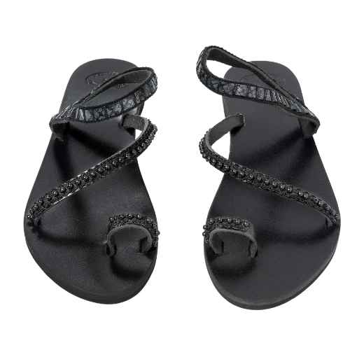 A black sandal with two crisscrossing upper straps and a toe loop, adorned with small beads or decorative elements.