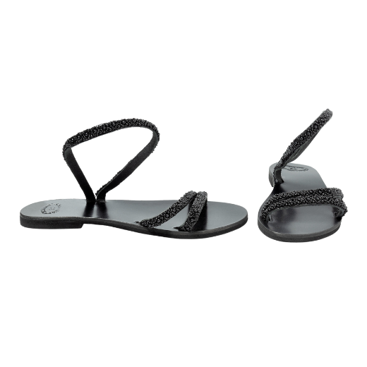 A black sandal with a single looped strap around the ankle and two thin upper straps, embellished with small decorative elements.