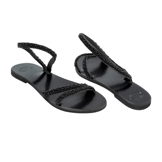A black sandal with a single looped strap around the ankle and two thin upper straps, embellished with small decorative elements.
