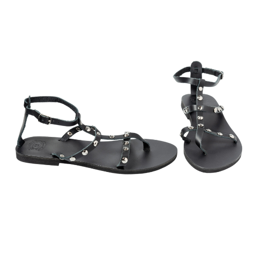 A black sandal featuring multiple thin straps, including one around the ankle and several on the upper foot, with metallic studs as embellishments.