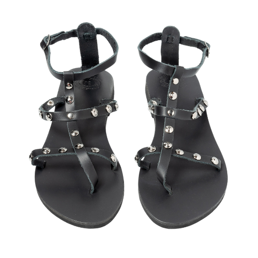 A black sandal featuring multiple thin straps, including one around the ankle and several on the upper foot, with metallic studs as embellishments.